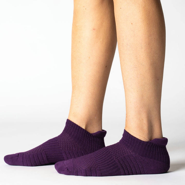 Unisex model wearing royal purple ankle support compression socks, showing ergonomic fit and style.