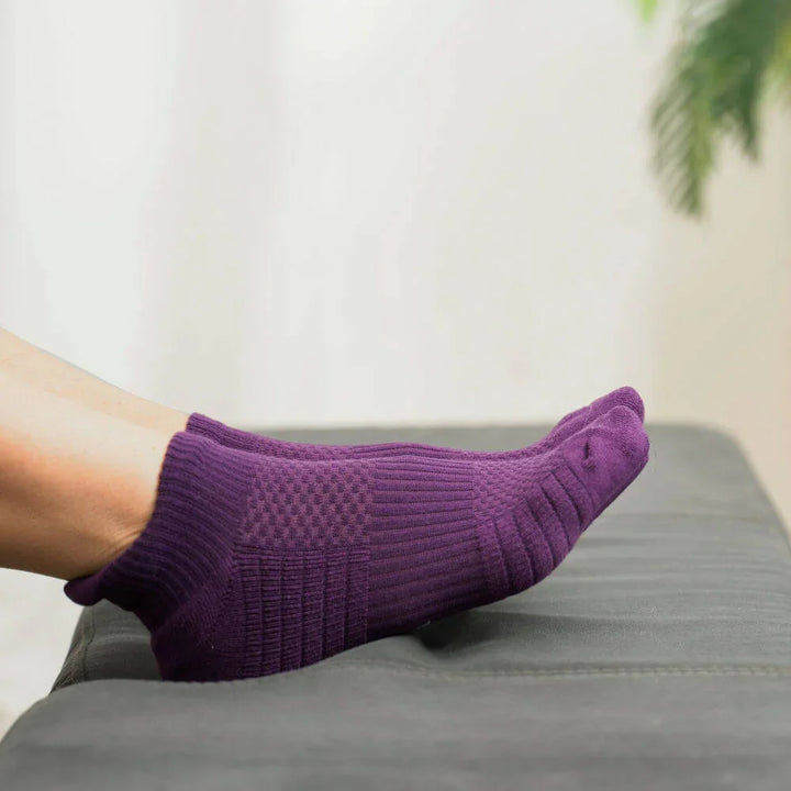 Stack of royal purple unisex compression ankle socks, emphasizing comfort, support, and circulation.