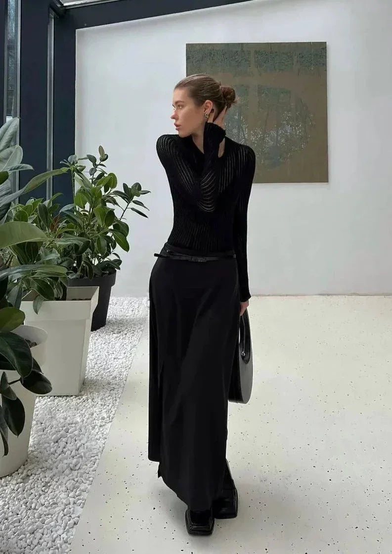 Fitted women's sheer ribbed long sleeve top in black, highlighting elegant silhouette. Chic & versatile modern apparel.