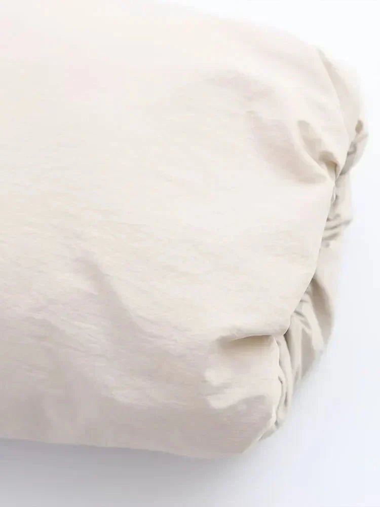 Close-up of a women's cropped insulated puffer jacket's fabric texture, highlighting its warmth