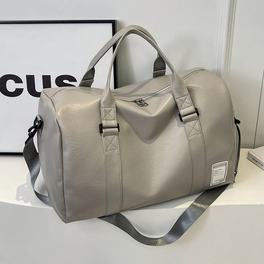 Detail of the sturdy handles and hardware on a genuine leather unisex overnight travel duffle bag