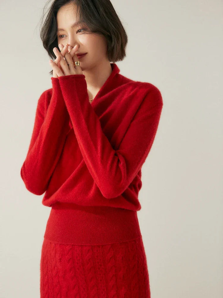 Woman posing in a vibrant red cashmere crossover sweater, premium knit