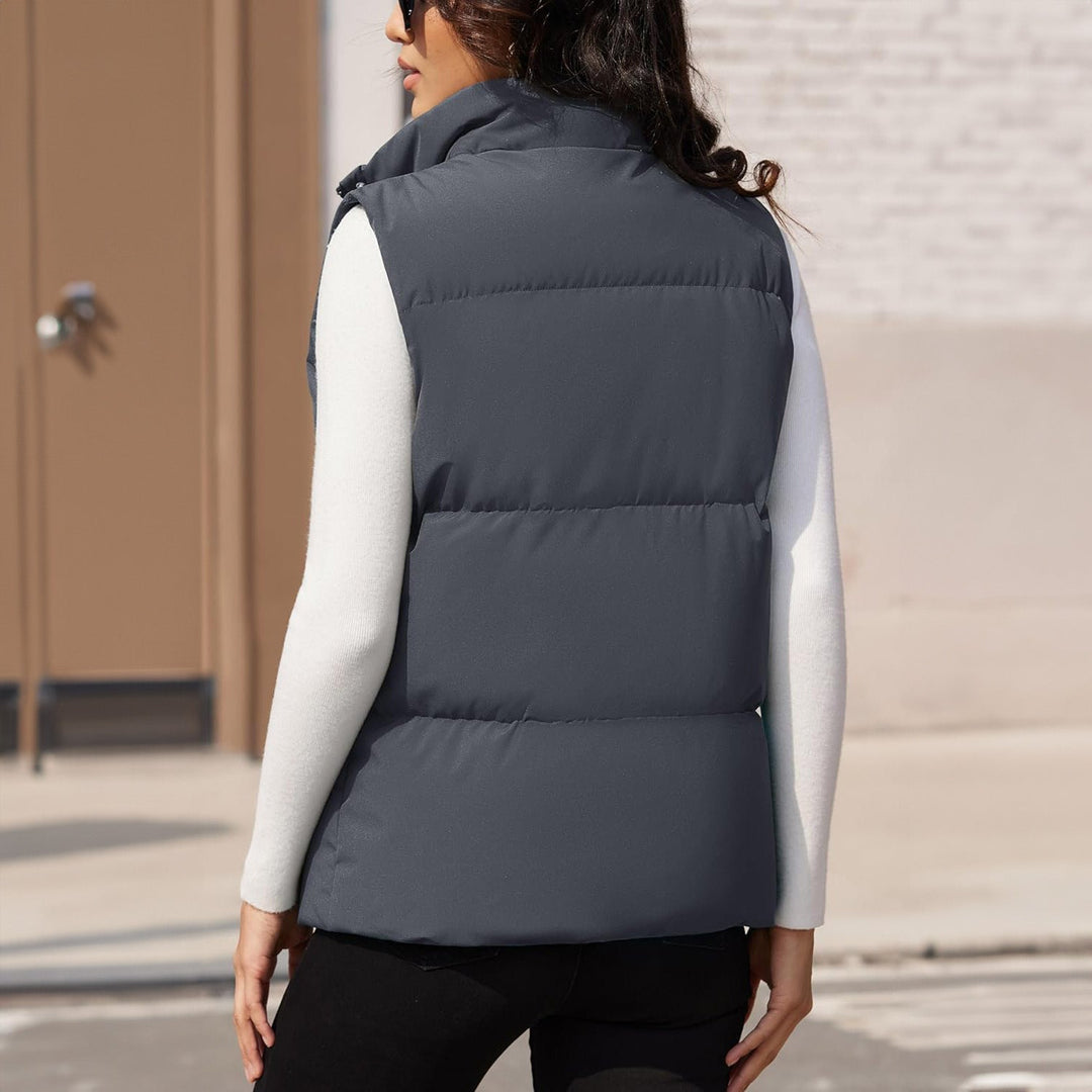 Women's black puffer vest, quilted, shown with a logo detail, branded outerwear for winter