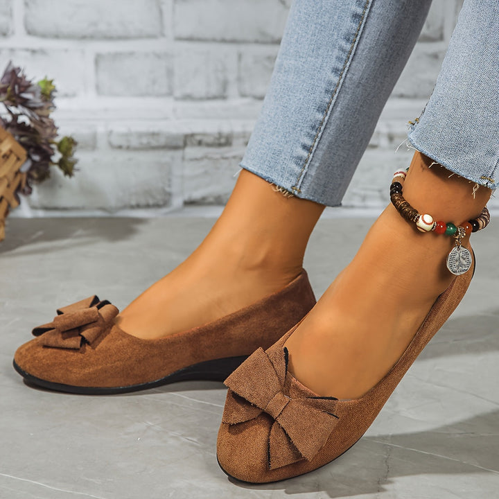 Women's round toe wedge flats, slip-on comfort and feminine bow accent.