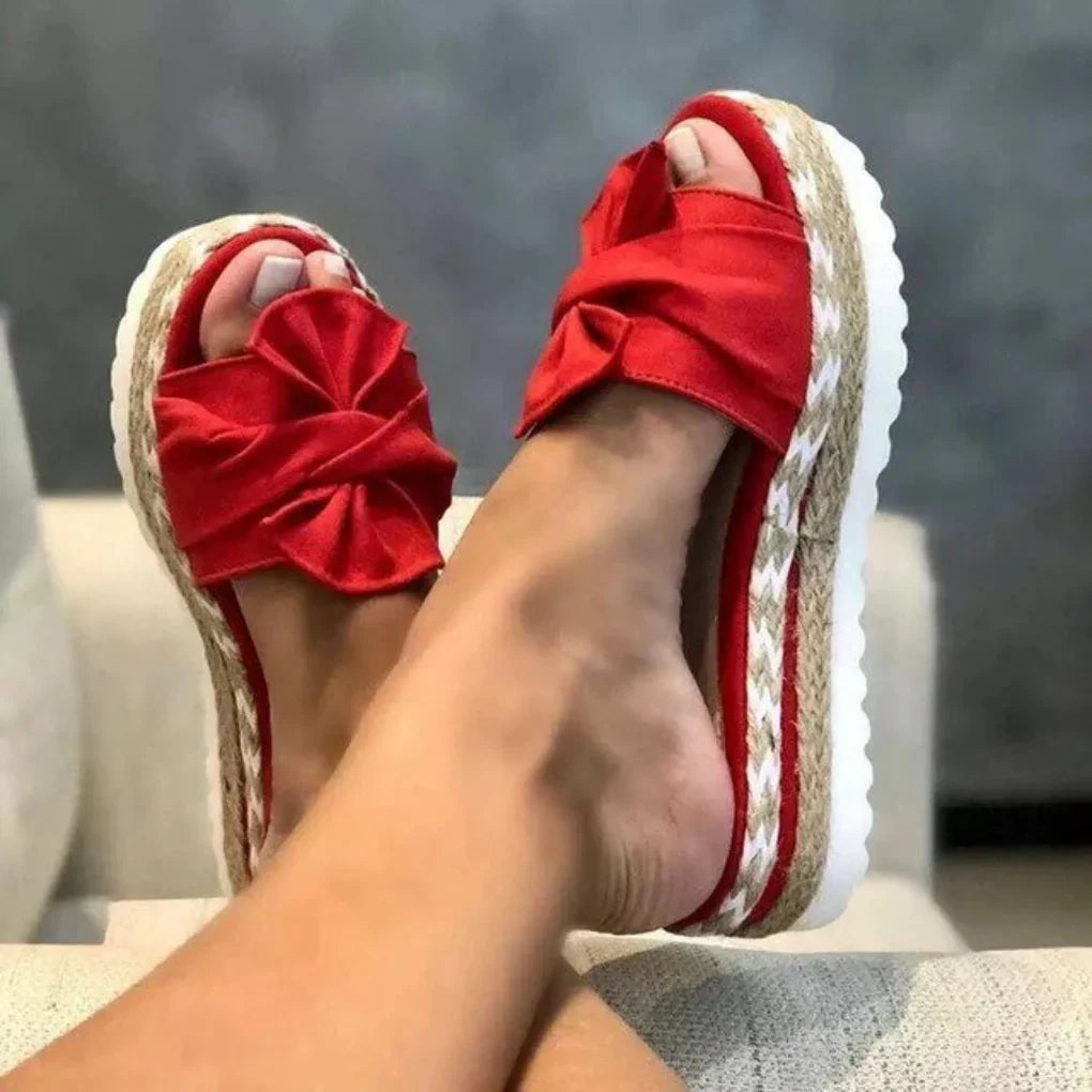 Durable women's platform slides with a charming bow, offering comfortable steps for summer outings