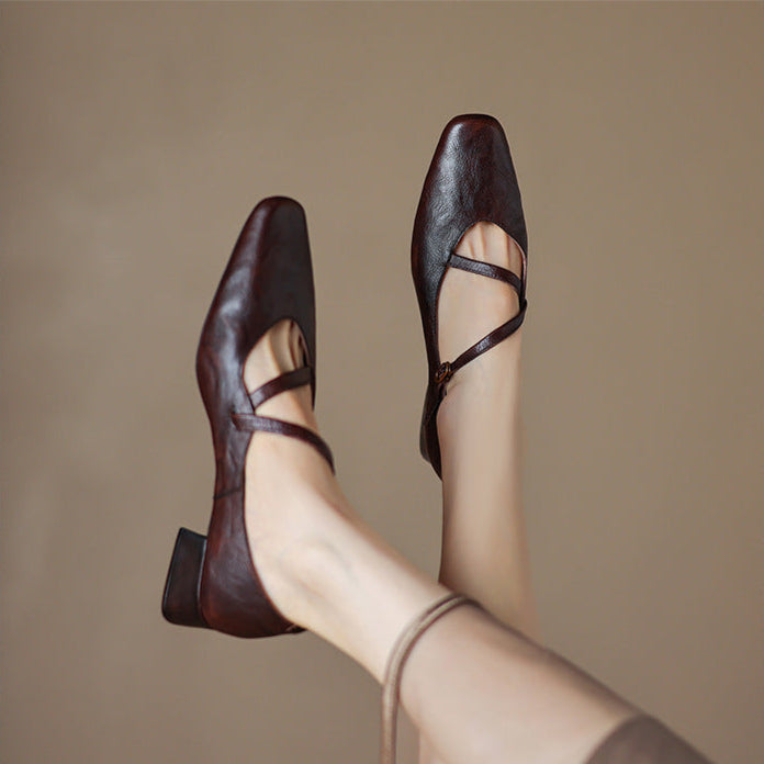 Front view of black leather tapered heel pumps, highlighting the sleek toe design
