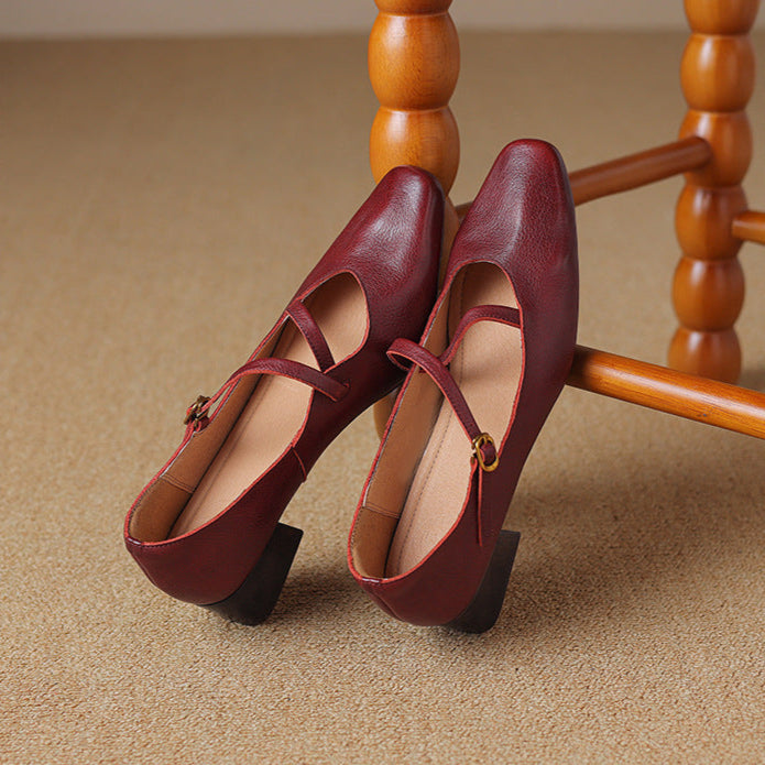 Side view of women's burgundy leather pumps, showcasing the sleek tapered heel design