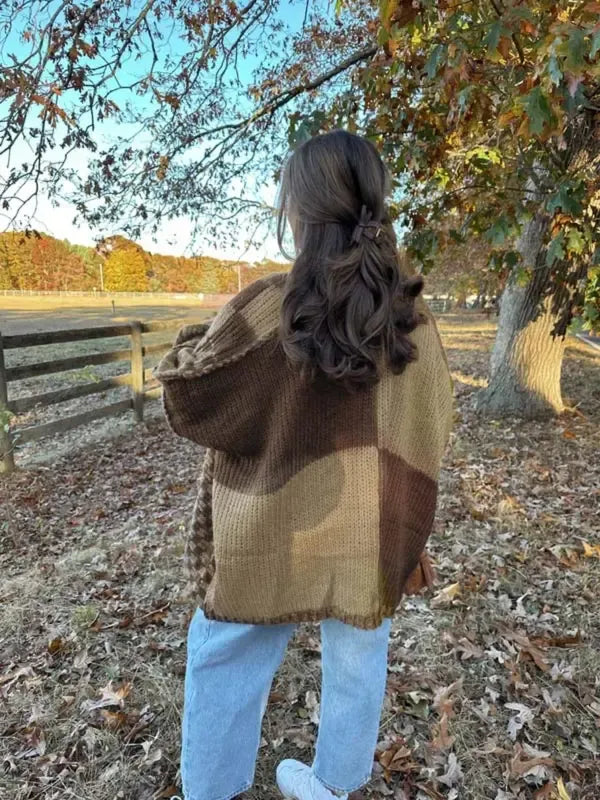 Detail shot of the check pattern on a women's chunky knit cardigan, acrylic blend fabric