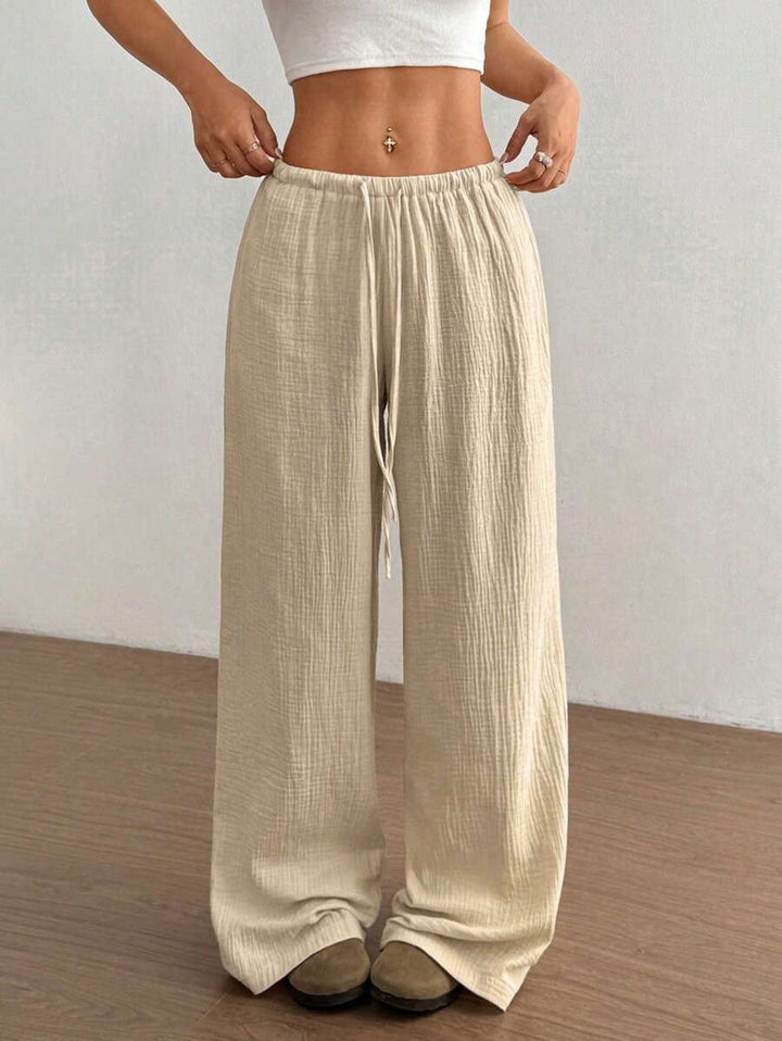 Relaxed fit women's wide leg crinkle pants, featuring a comfortable drawstring waist for effortless style.