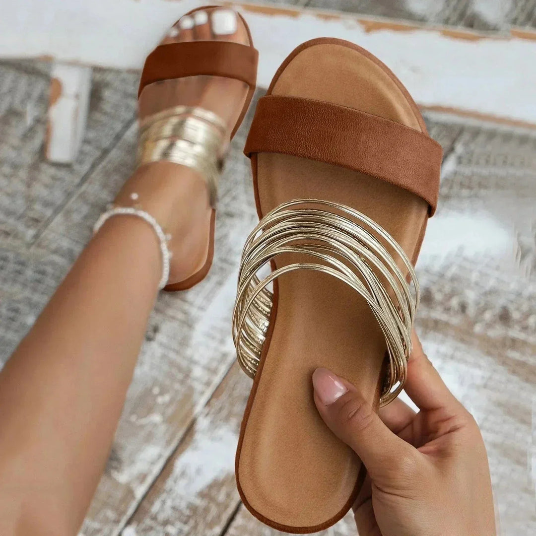 Chic women's flat slip-on sandals. Effortless open-toe design for summer vacation style.