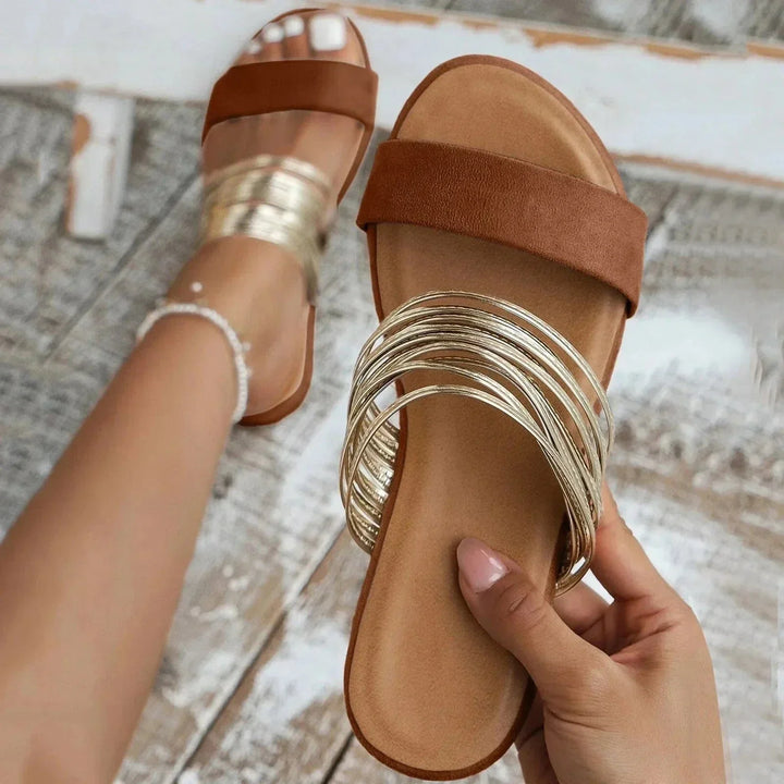 Chic women's flat slip-on sandals. Effortless open-toe design for summer vacation style.