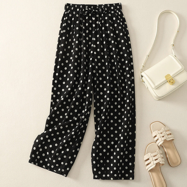Women's elegant black and white polka dot wide-leg pants with elastic waist; front view, flowy casual trousers