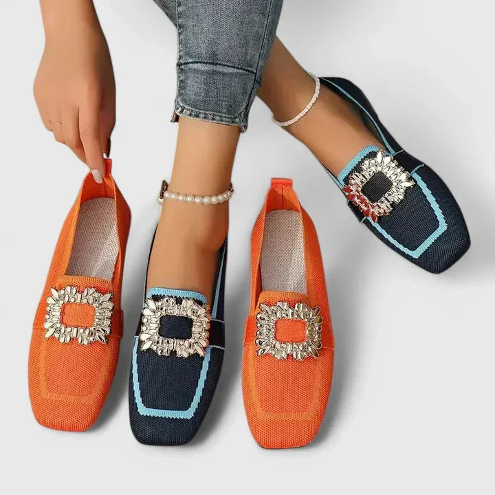 Elegant women's flat loafers in black with a distinctive square toe and sparkling crystal embellishment.