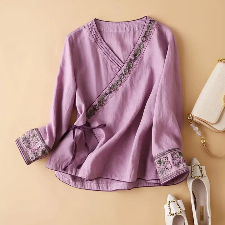 Women's stylish patterned top, V-neck, relaxed fit. Casual blouse with elegant design.
