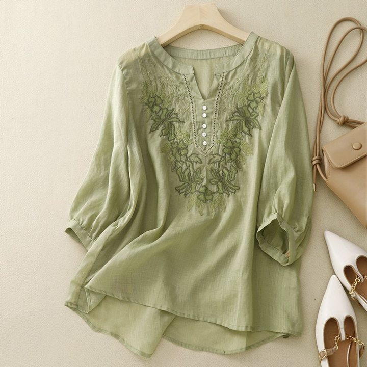 Women's elegant white linen blouse with delicate floral embroidery, perfect for summer casual wear