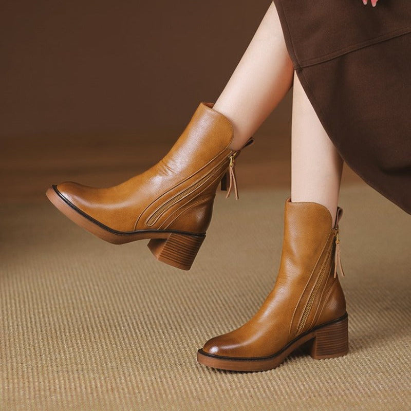 Elegant black high heel ankle boots for women, featuring a chic metal zipper & comfort heel.
