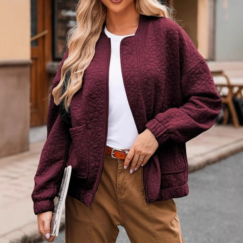 Women's black quilted jacket with padding, offers essential warmth and includes convenient pockets for outerwear.