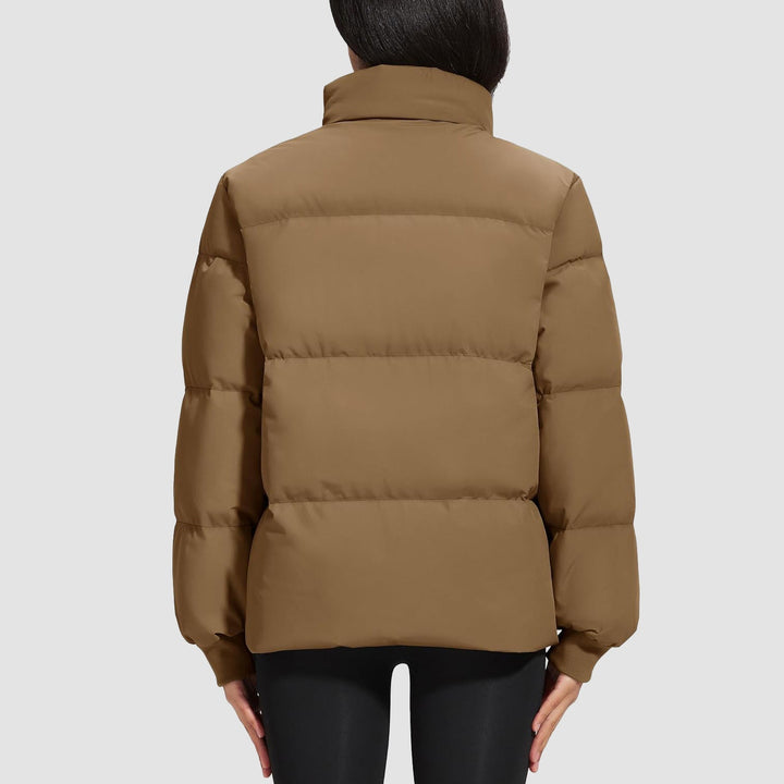 Close-up of the hem of a black quilted women's jacket, showing elasticized finish