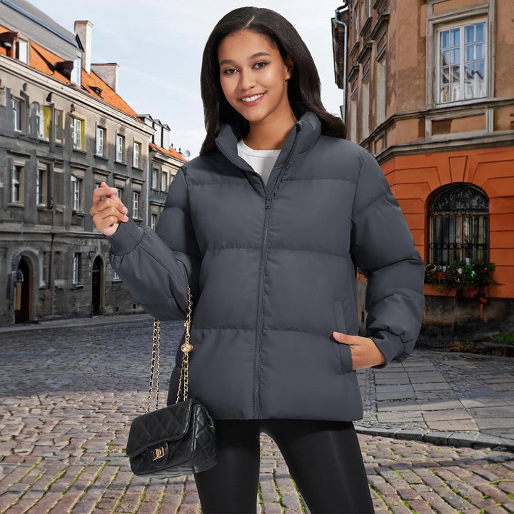 Woman entering a building, wearing a black lightweight puffer jacket, urban fashion