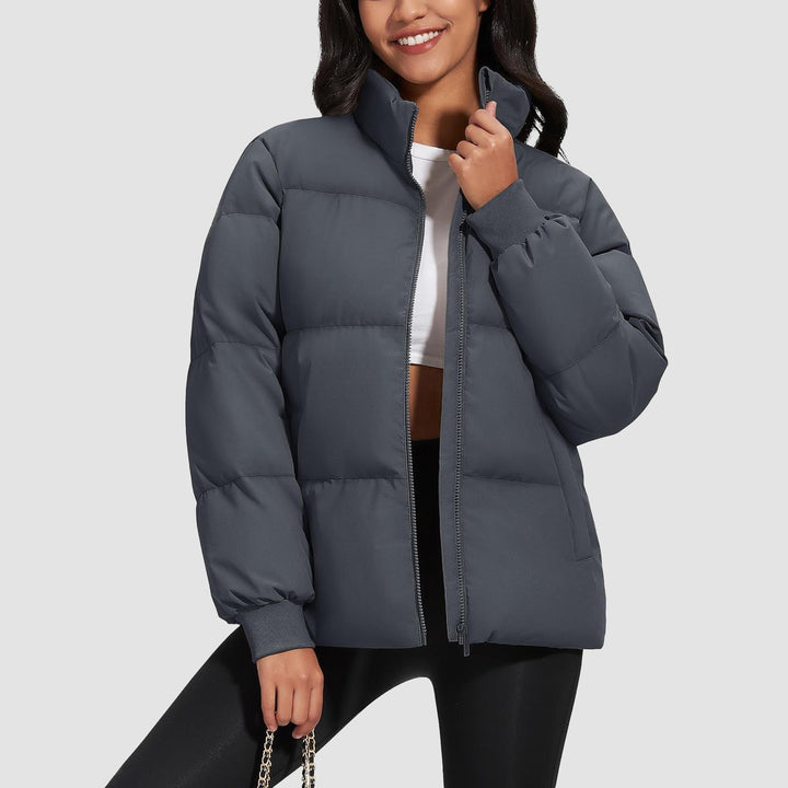Woman zipping up her lightweight black quilted puffer jacket, ready for cold weather