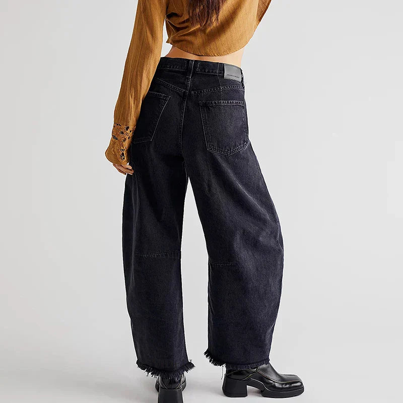 Model wearing women's organic cotton high-rise loose fit jeans with a stylish straight leg and frayed hem.