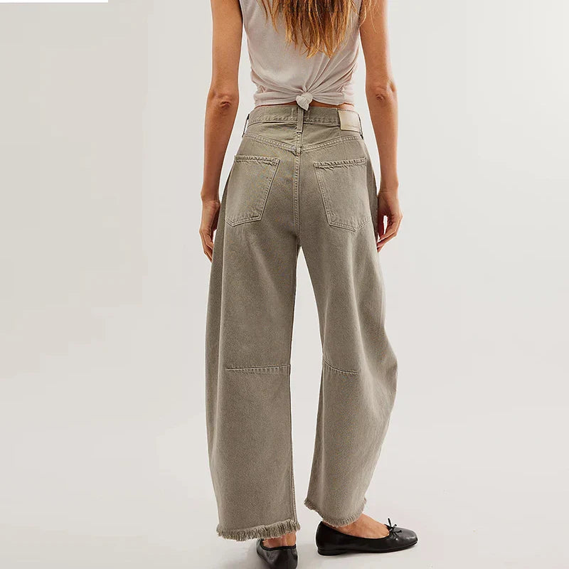 Sustainable women's high-rise loose fit jeans, organic cotton with a straight leg and fashionable frayed hem.
