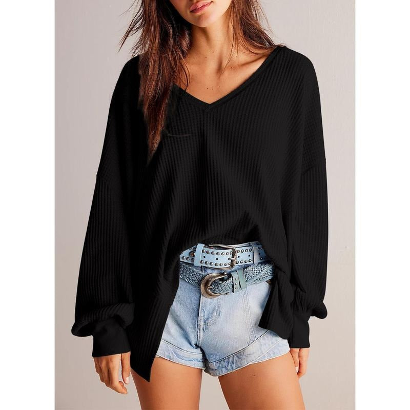 Detail of the V-neckline of a women's knit sweater, highlighting the soft, comfortable design