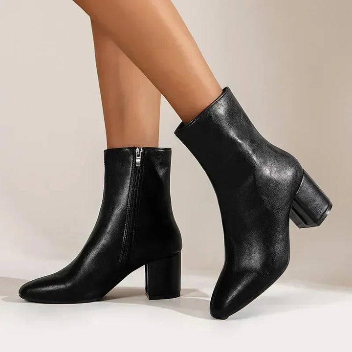 Close-up of women's premium leather ankle boots, showcasing quality leather texture, block heel, and elegant almond toe.