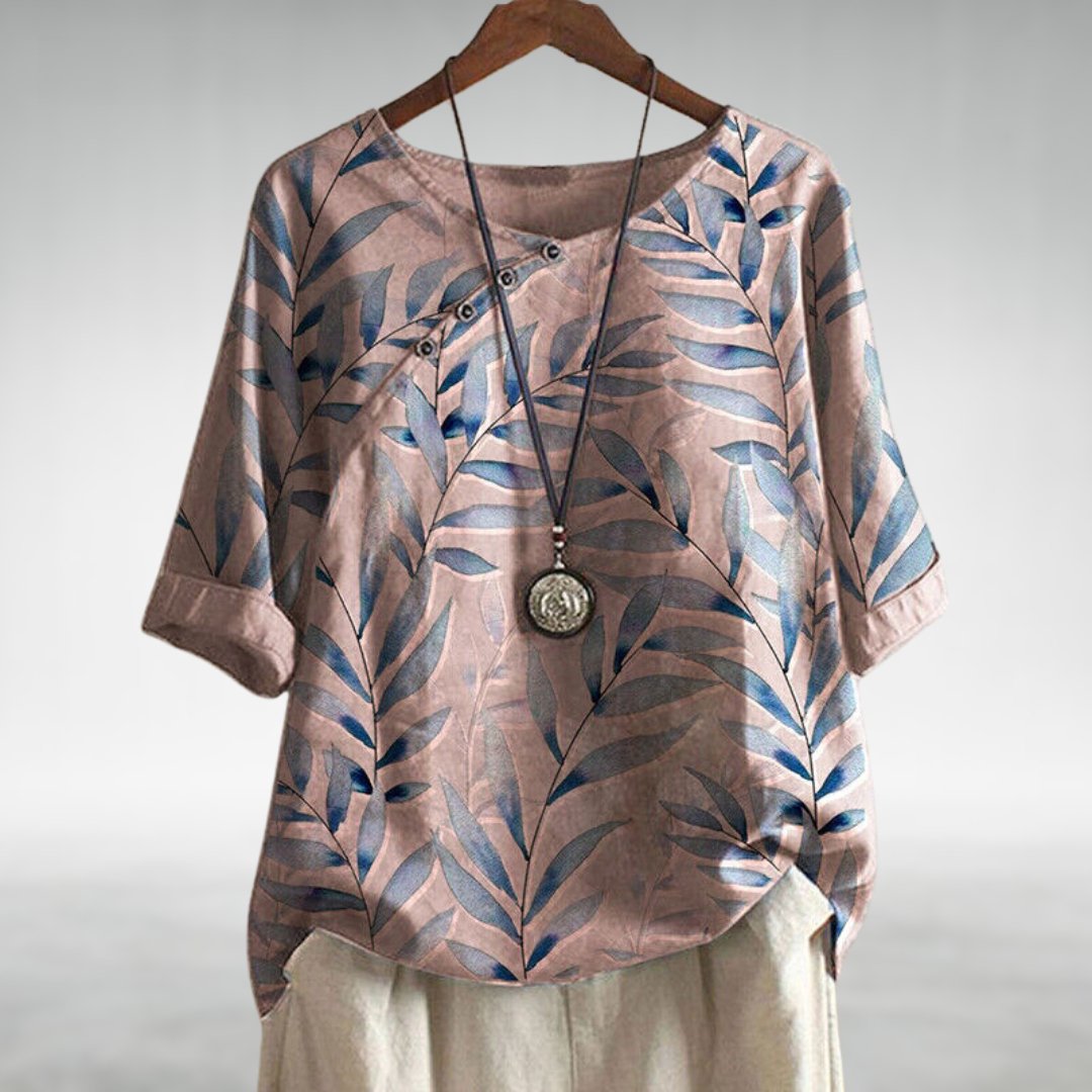 Blue women's printed top featuring a stylish leaf design & trendy asymmetric buttons.