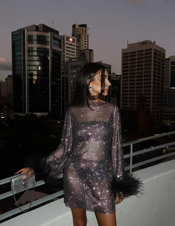 Women's sheer sequin mini cocktail dress with glamorous feather cuffs, perfect for parties.