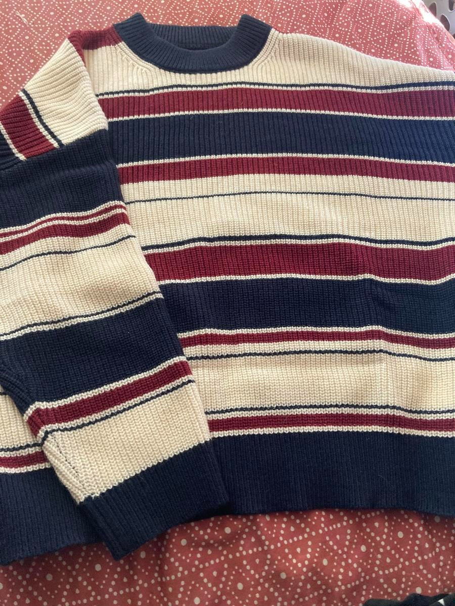 Close-up of a women's striped knit wool blend sweater, showcasing the soft texture and relaxed fit