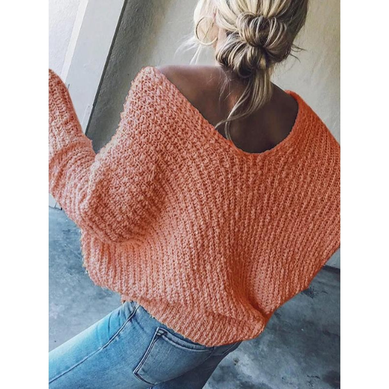 Back view of a women's textured knit V-neck sweater, highlighting its casual design.