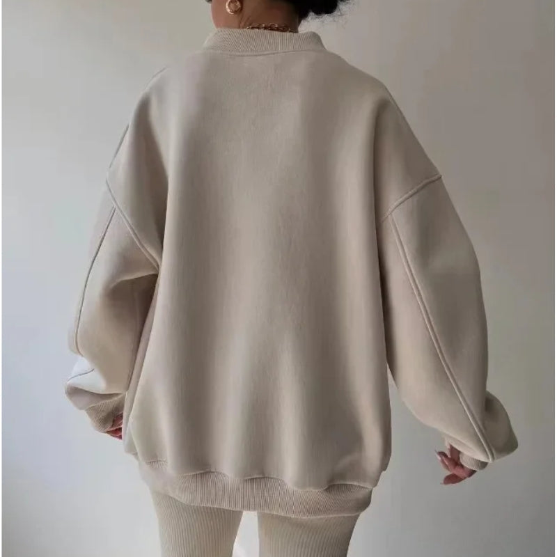 Beige long sleeve women's oversized pullover with a relaxed fit and crew neck, made from soft knit fabric.
