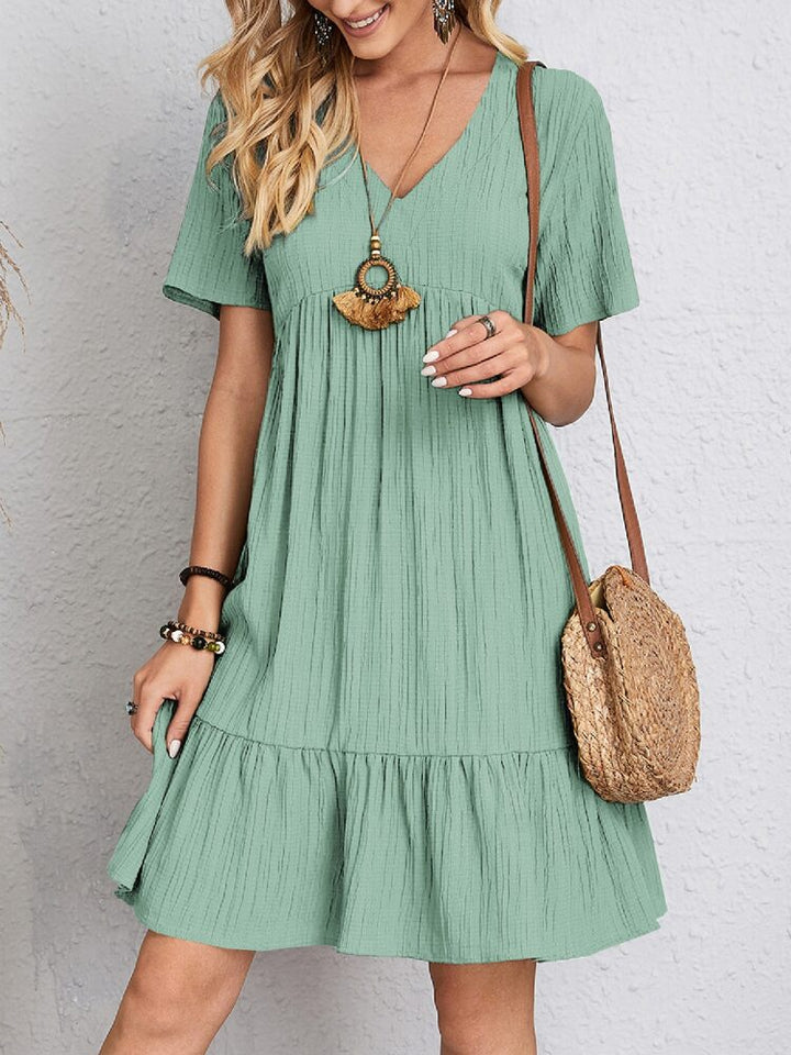 Effortlessly stylish women's V-neck tiered mini dress, short sleeve. Perfect casual summer fashion.