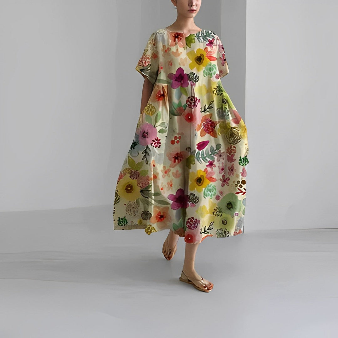 Women's vibrant floral maxi dress in a garden setting, ideal casual summer or vacation fashion.