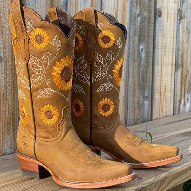 Statement women's cowboy boots showcasing detailed sunflower embroidery on a mid-calf western silhouette. Great for any outfit.