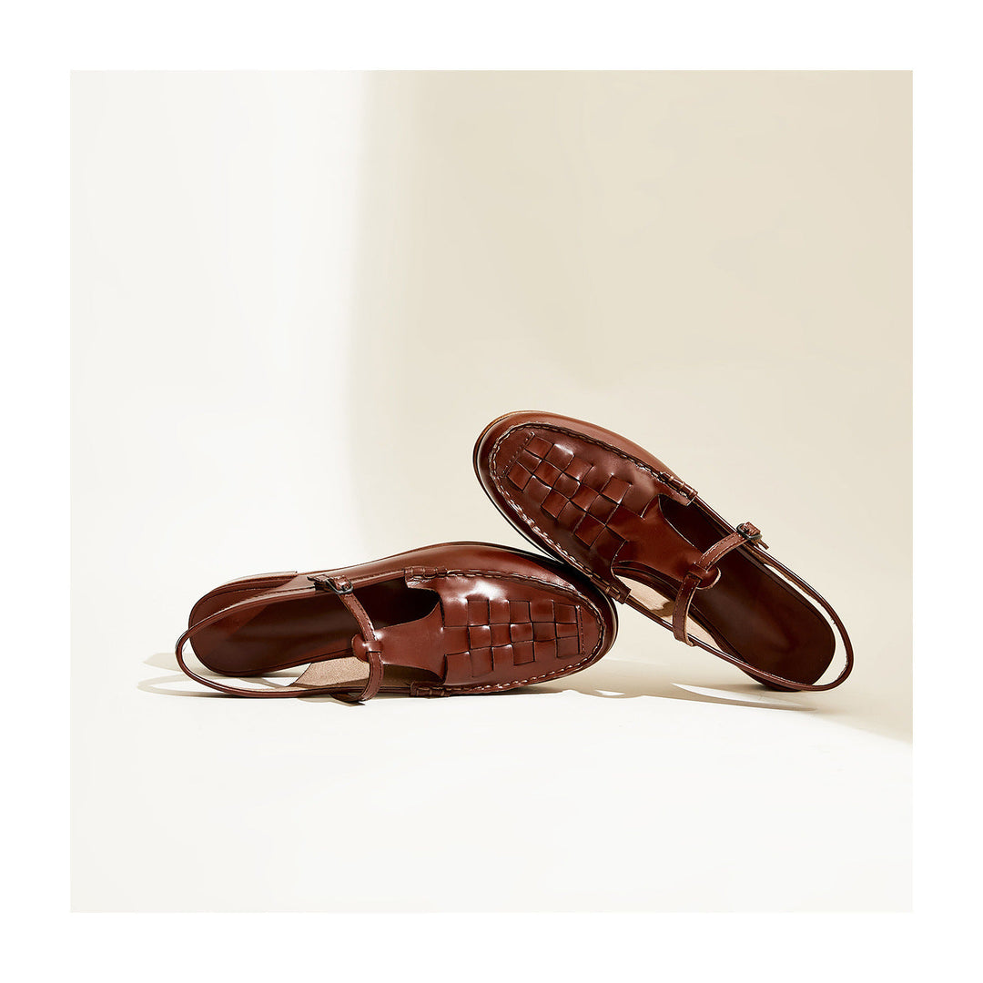 Pair of women's leather slingback flat sandals, showcasing the woven upper design.