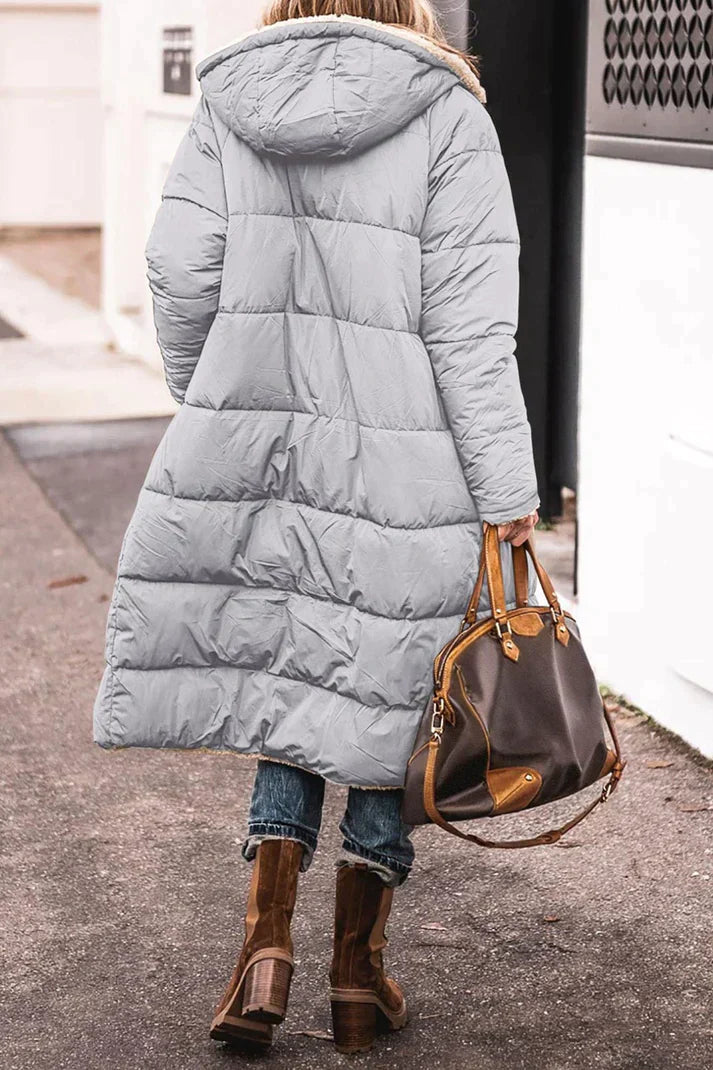 "Women's hooded longline quilted winter coat, front view; insulated, open front design with quilted texture and hood."