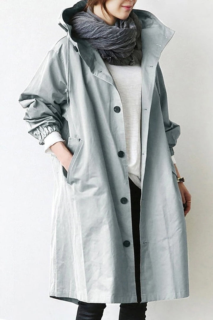 Women's hooded waterproof trench coat, front view. Adjustable hood, belted waist, available in various colors.