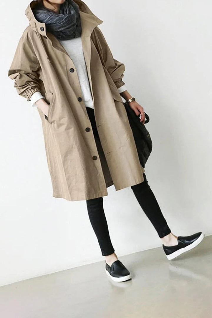 Women's hooded waterproof trench coat, front view. Adjustable hood, belted waist, available in various colors.
