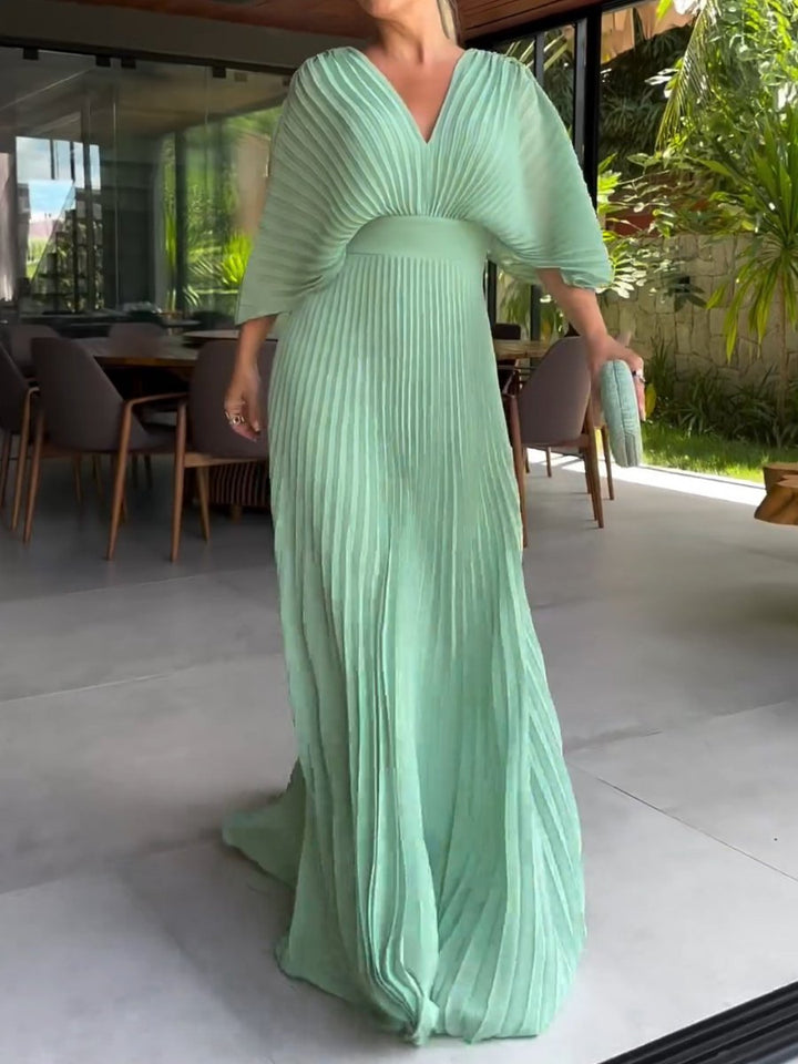 Women's pleated maxi dress with V-neck, batwing sleeves, defined waistband, elegant full-length, seen in front view.