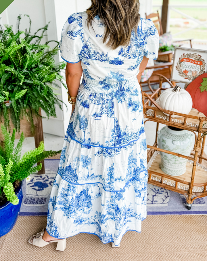 Women's toile print maxi dress with puff sleeves, showcases vintage charm with a scenic motif and fitted silhouette.