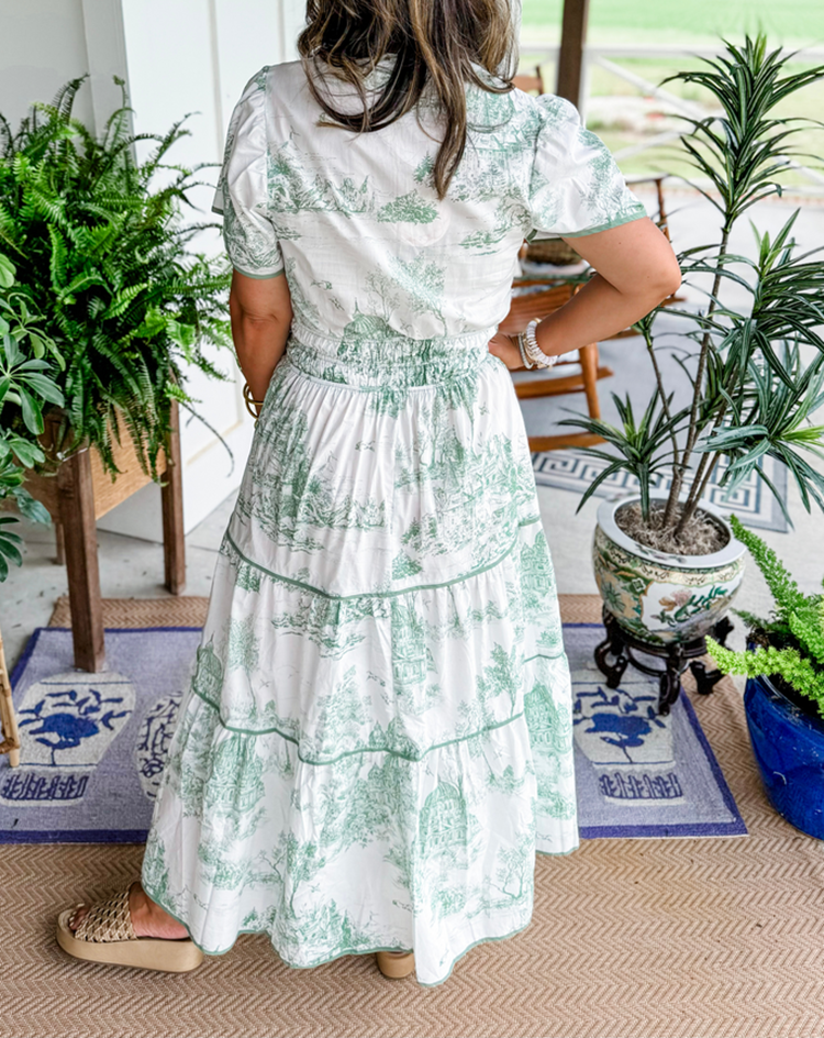Women's toile print maxi dress with puff sleeves, showcases vintage charm with a scenic motif and fitted silhouette.
