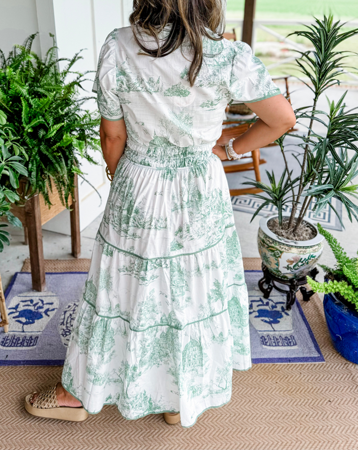 Women's toile print maxi dress with puff sleeves, showcases vintage charm with a scenic motif and fitted silhouette.