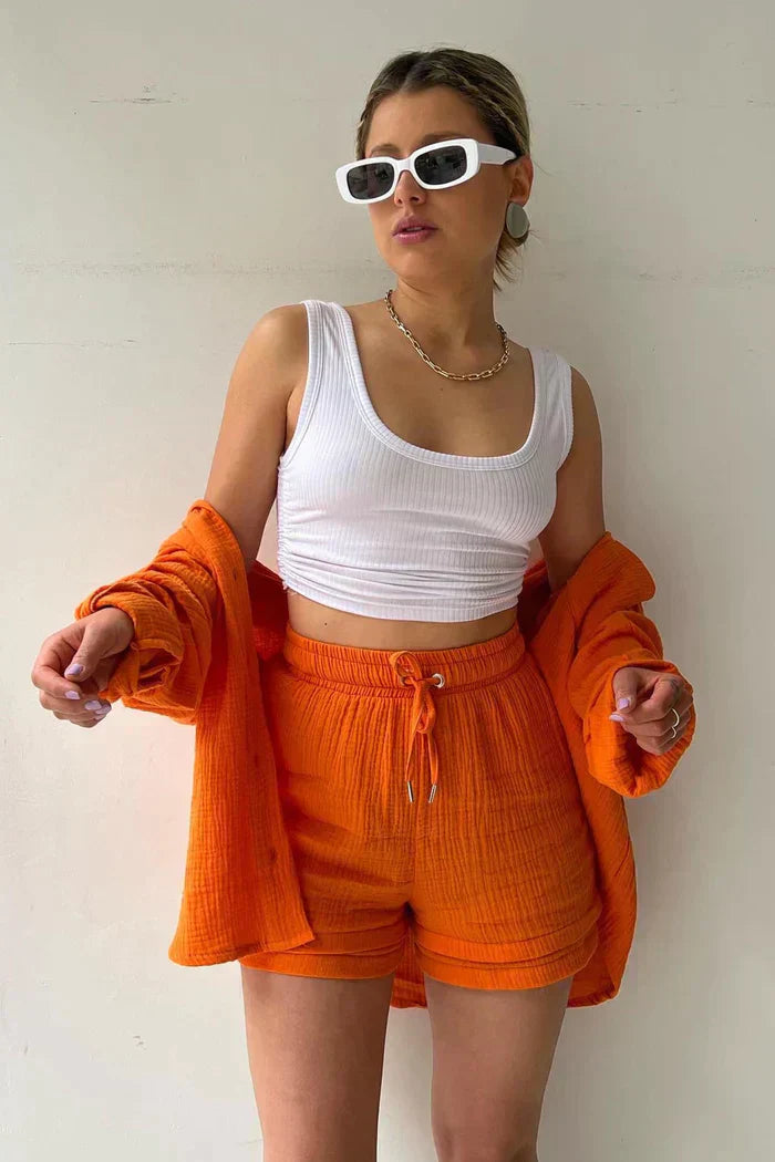 Women's vibrant summer lounge set featuring a button-up shirt and high-waist shorts in a bold, casual style.